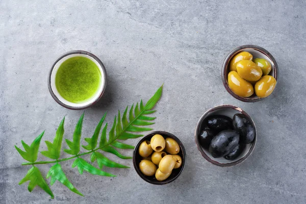 Sortimento antipasto, azeitonas pretas, verdes, molho pesto com manjericão — Fotografia de Stock