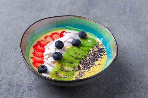 Vegetarian mango smoothie bowl, kiwi, chia, coconut, blueberry, strawberry — Stock Photo, Image