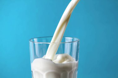 Mavi bir arka plan üzerine bir bardak sütte sıçramasına