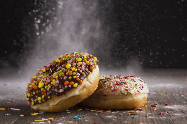 Ahşap bir masa üzerinde çörek ve ile pudra şekeri serpilir.