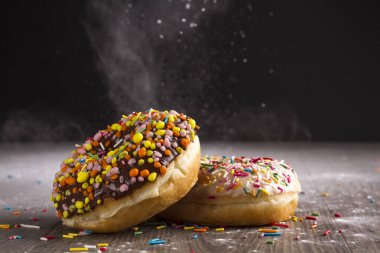 Ahşap bir masa üzerinde çörek ve ile pudra şekeri serpilir.