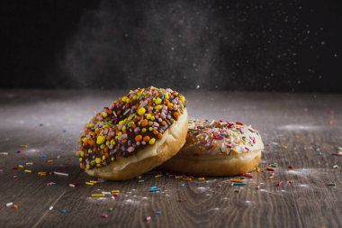 Ahşap bir masa üzerinde çörek ve ile pudra şekeri serpilir.