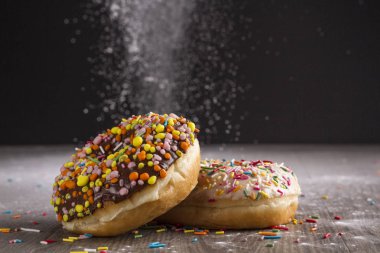 Ahşap bir masa üzerinde çörek ve ile pudra şekeri serpilir.