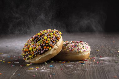 Ahşap bir masa üzerinde çörek ve ile pudra şekeri serpilir.