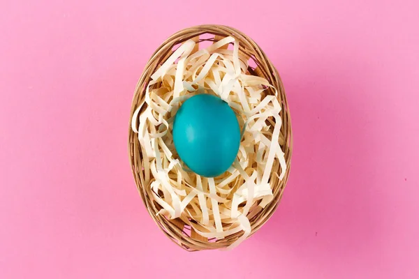 blue Easter egg in the easter basket on the bright background