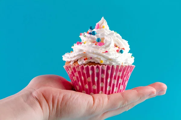 Χέρι Που Κρατά Muffin Σκόνη Κρέμας Και Φωτεινό Φωτεινό Φόντο — Φωτογραφία Αρχείου