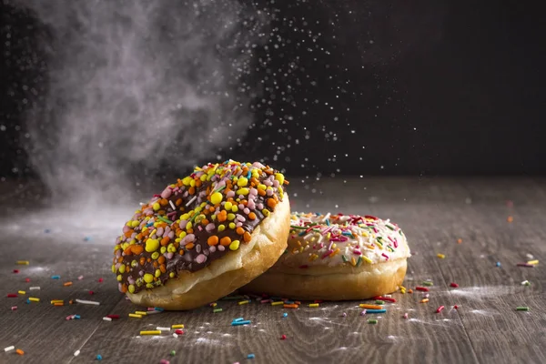 Ahşap bir masa üzerinde çörek ve ile pudra şekeri serpilir.