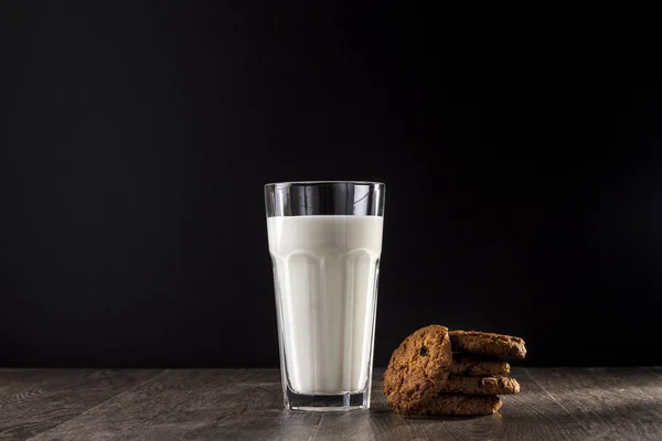 Biscotto Bicchiere Latte Tavolo Legno Uno Sfondo Nero — Foto Stock