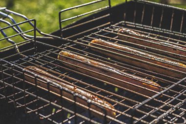 Sosis ızgara çekerek. Odun ve kömür ile kırmızı kiremit.