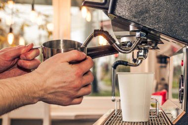Barista sıcak cappuccino kahve makinesi ile hazırlar..