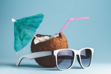 Kokteyl mavi zemin üzerine Hindistan cevizi ve beyaz güneş gözlüğü