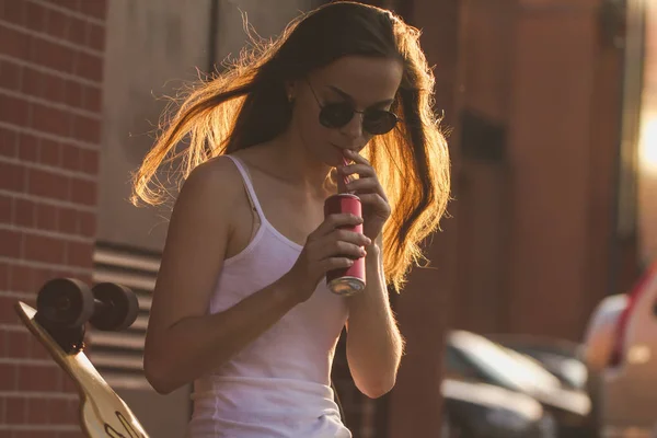 Mädchen Mit Schwarzer Sonnenbrille Sitzt Mit Langem Brett Und Trinkt — Stockfoto