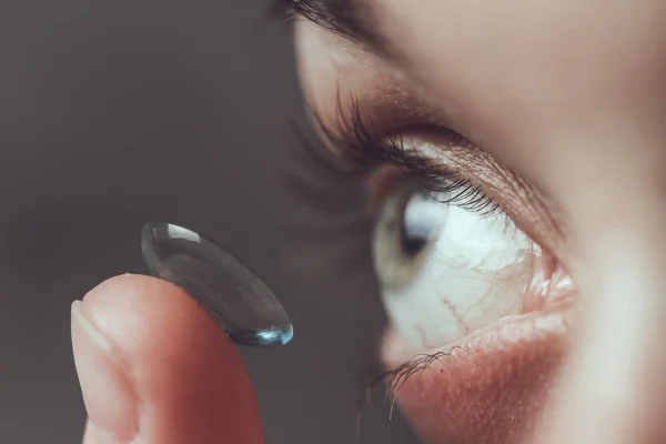 Close up of female eye and contact lens