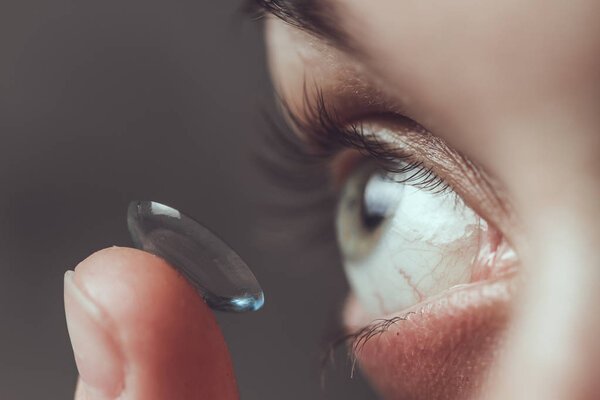 Close up of female eye and contact lens 