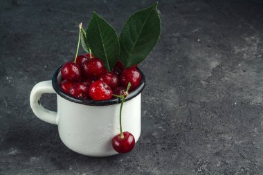 Damla siyah arka plan üzerine beyaz Kupası'nda kırmızı, olgun kiraz