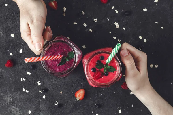 年轻女孩拿着玻璃罐新鲜的甜果汁从树莓和蓝莓 — 图库照片