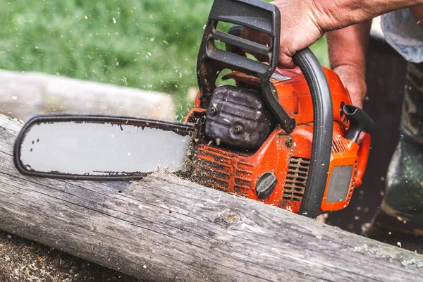 Detail view of man cutting wood with electric saw