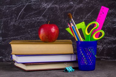 Eski püskü siyah arka plan üzerine görünümü Kapat kitap, apple ve okul malzemeleri.