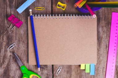 Kopya alanı ile ahşap arka plan üzerinde okul malzemeleri.