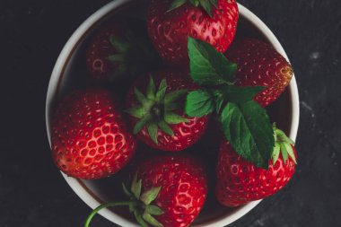 En iyi görünümü nane ve çilek beyaz fincan siyah arka plan üzerine bırakır..