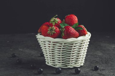 Taze çilek ve siyah arka plan üzerine beyaz sepet içinde yaban mersini. Vitaminler. Tatlı çilek.