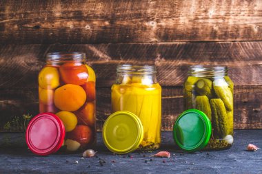 Kavanoz turşu kabak, salatalık ve domates ahşap arka plan ile. Uzay kopyalayın. Sonbahar