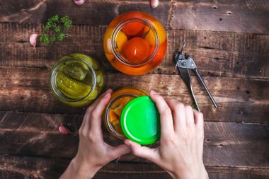 Ev yapımı turşu kavanozları taze salatalık, sulu domates, ahşap arka plan üzerinde tatlı kabak. Yemek hazır. Sonbahar kavramı. Üstten görünüm