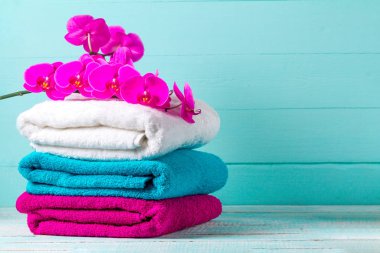 Havlu ve mavi bir arka plan üzerinde bir orkide bir dalı. Aromaterapi. Spa. Hijyen. Kopya alanı