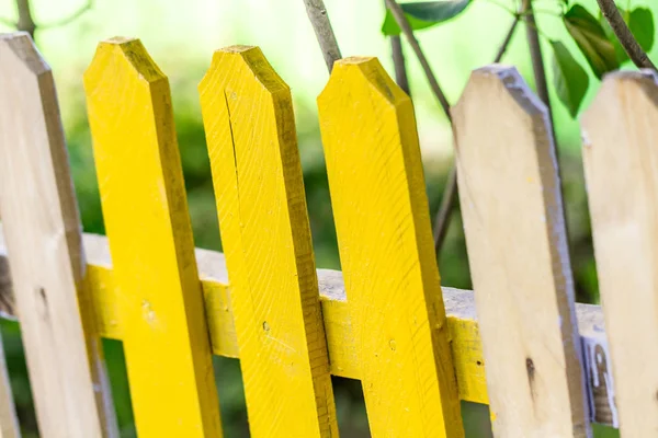 Painting the fence with yellow paint. Repair concept