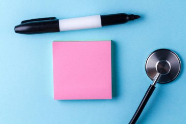 Steteskop ve sopa için mavi bir arka plan üzerine notlar. Yazmak iletilerini, anımsatıcıları, tıbbi reçete, ilaçların adı. Üstten görünüm. Kopya alanı