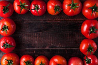 Ahşap arka plan üzerinde taze, olgun domates yapılan metin için çerçeve. Uzay kopyalayın. Üstten görünüm