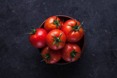 Karanlık bir arka plan üzerinde kırmızı, olgunlaşmış domates. Domates hasat. Üstten görünüm