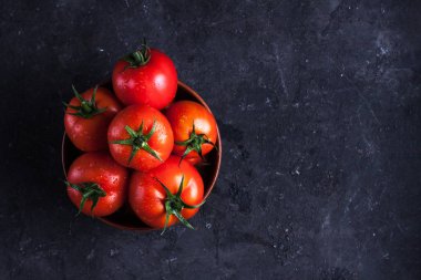 Karanlık bir arka plan üzerinde kırmızı, olgunlaşmış domates. Domates hasat. Üstten görünüm