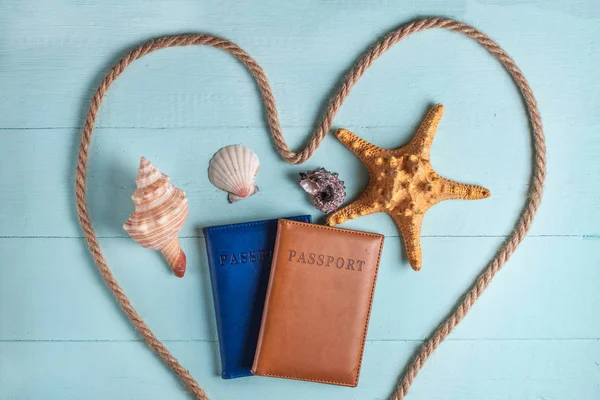 Concept of travelling, holidays, sea cruise. Passports, seashells and rope on a wooden background. Vacation. Flat lay, top view
