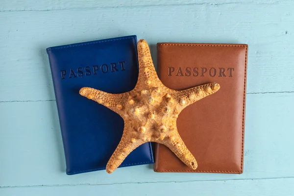 The concept of travel, recreation, cruise. Holidays. Passports, seashells, starfish on a blue, wooden background. Top view. Toutism