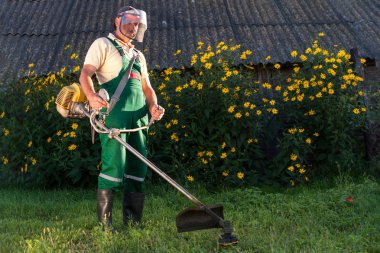 Bahçıvan tulum içinde çim Bahçe çim biçme makinesi ile mows.