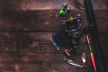Balık tutma malzemeleri ahşap arka plan üzerinde. Boş kağıt sayfası. Balıkçılık aksesuarları. Üstten görünüm, kopya alanı