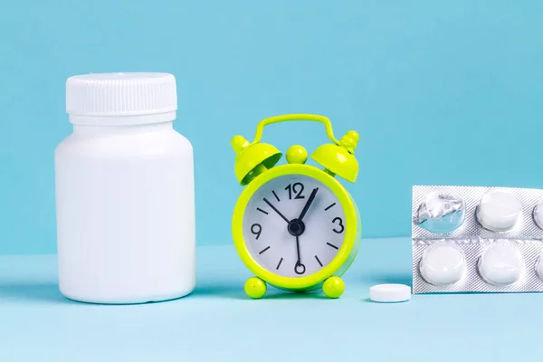 Väckarklocka Piller Burk Medicin Blå Bakgrund Uppvaknande Vakna Upp Tidigt — Stockfoto