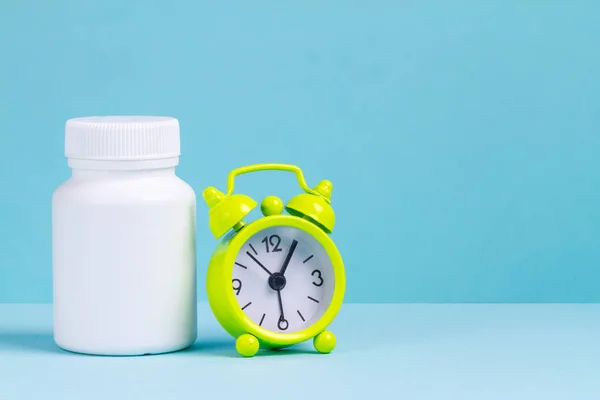 Alarmklok Pillen Een Pot Van Geneeskunde Een Blauwe Achtergrond Ontwaken — Stockfoto