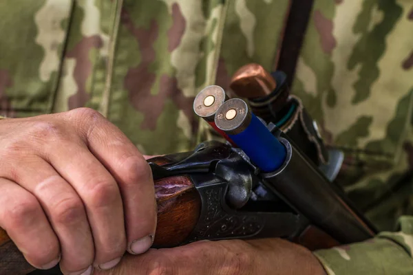 Cartridges for hunting in a hunting gun in the hands of a hunter close-up.