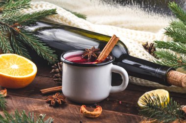 Mulled şarap, bir şişe kırmızı şarap, çam dalları, tarçın, anason ağaç, portakal ve limon ahşap arka plan üzerinde. Rahat, kış bir akşam. Kış içer. Noel arifesi