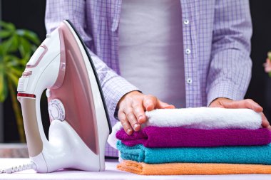 Bir gömlek kıvrımlar temiz havlu Ütü Ütü masası üzerinde sonra içinde bir genç ev hanımı. Ev rutinleri. Giysi ve Çamaşırhane Ütü