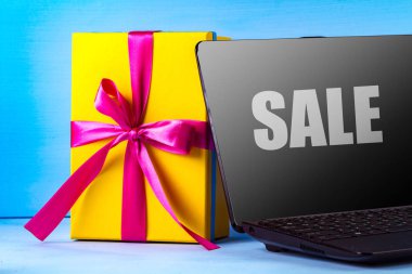 Hediye ve mavi bir arka plan üstünde laptop. Online alışveriş. Internet üzerinde mal alımı. Kavram, Satılık konsept alışveriş. Satış ve indirimler. 