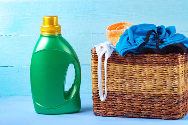 Корзина с грязной, разнообразной, цветной одеждой, прачечная для стирки и стирального порошка на синем фоне
