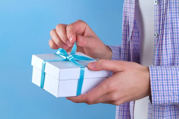 Female hands open a gift box. Christmas, New Year, birthday gifts. Surprises.