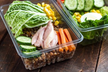 Plastik bir kap içinde sağlıklı yemek. Ofiste, işyerinde yemek saati. Salatalık, karabuğday, et, havuç, yumurta, marul ve konserve mısır yemek kutusu. Beslenme ve sağlıklı gıda kavramı