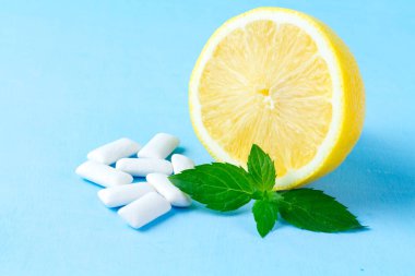 Taze nane ve sulu limon mavi bir arka plan üzerinde bir parça sakız. Taze bir nefes