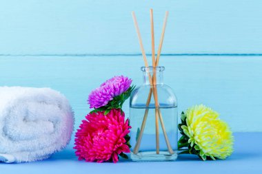Spa. Hava difüzörü, havlu ve mavi bir arka plan üzerinde çiçekler. Aromaterapi, gevşeme. Spa uygulamaları