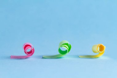 Mavi bir arka plan üzerinde yırtık ve bükülmüş renkli kağıttan koleksiyonu