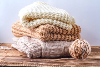 Örme, sıcak, pastel, pastel renkli eşarplar ve giysi beyaz bir arka plan üzerinde iplik örgü bir topu. Kış, sonbahar kıyafetleri.